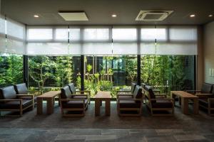 a lobby with tables and chairs and large windows at Hotel Route Inn Shikoku Chuo in Shikokuchuo