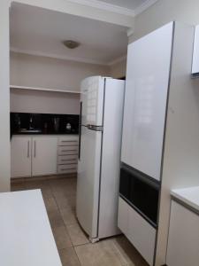 uma cozinha com um frigorífico branco e armários brancos em Espacin Maricris-28 min. Thermas Sao Pedro em Piracicaba
