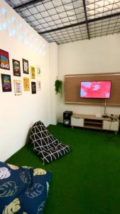 sala de estar con alfombra verde y TV de pantalla plana en Villa Tiga Dara Batu en Batu