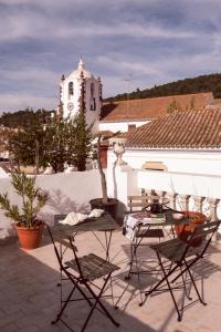 un patio con sedie e tavolo e un edificio di Bartholomeu Guesthouse a São Bartolomeu de Messines