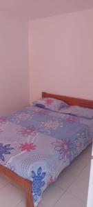 a bed with a purple comforter with flowers on it at Apartamento Santa Marta Piscina cerca del Rodadero in Santa Marta +4 photos