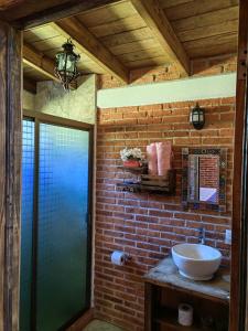 baño con lavabo y pared de ladrillo en CABAÑAS LOS LAURELES, en Huasca de Ocampo