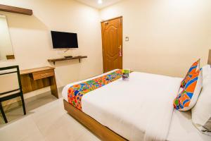 a bedroom with a bed and a desk and a television at FabHotel Thejas Paaradise Coimbatore International Airport in Coimbatore