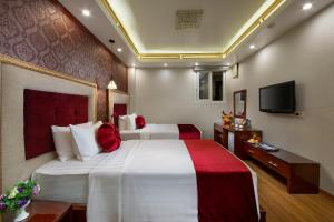 a hotel room with a large bed and a tv at Hanoi Lotus Boutique Hotel in Hanoi