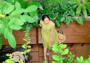 a woman in a yellow dress standing next to a fence at 5-homestay I in Vung Tau