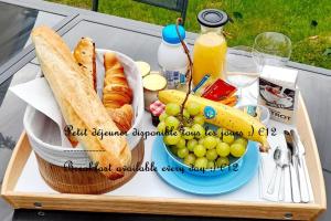 a tray of food with a basket of grapes and a sandwich at Villa Carlotta - Sea resort in Dieppe