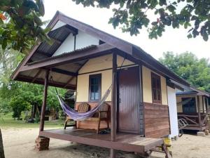 a small house with a hammock in front of it at Pinks Bungalow in Baan Tai
