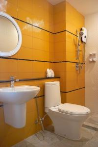 a bathroom with a sink and a toilet and a mirror at Villa Blanca Hotel & Restaurant in Chao Lao Beach