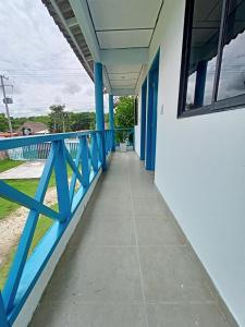 einem Korridor eines Gebäudes mit einem blauen Geländer in der Unterkunft Cabañas Cigua in Coveñas