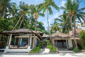 una casa sulla spiaggia con palme di Harlan Beach Villa Boracay a Boracay