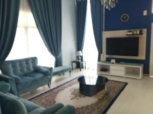 uma sala de estar com um sofá e uma televisão em Oilclique By The Sea Guesthouse em Dungun