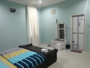 um quarto com uma cama e uma parede azul em Oilclique By The Sea Guesthouse em Dungun