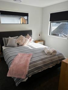 a bedroom with a large bed with pillows and a window at Coronet Haven in Queenstown