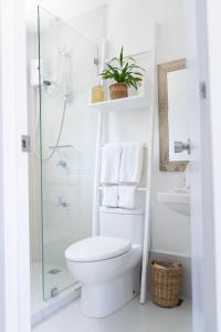 a white bathroom with a toilet and a shower at Sea Green Boutique Rooms in General Luna