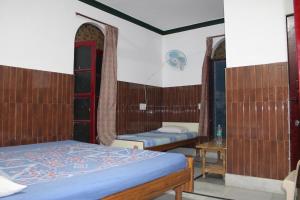 Laxmi Lodge في ريشيكيش: غرفة بسريرين وطاولة في غرفة