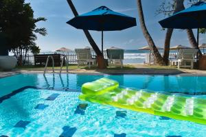 - une piscine avec un radeau gonflable et un parasol dans l'établissement Smeralda Beach Hotel Dikwella, à Dikwella