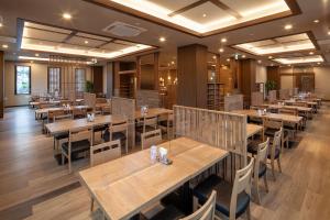 uma sala de jantar com mesas e cadeiras de madeira em Hotel Route Inn Shunan - Tokuyama Higashi Inter - em Shunan