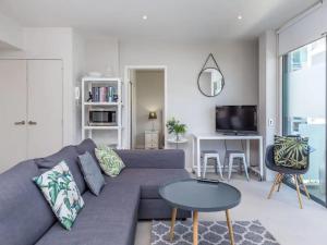 a living room with a blue couch and a table at Wynyard Viaduct Habour 2 brm 2 bath and carpark in Auckland