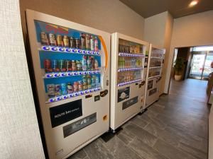 uma fila de máquinas de venda automática de refrigerantes numa loja em Hotel Route Inn Shunan - Tokuyama Higashi Inter - em Shunan