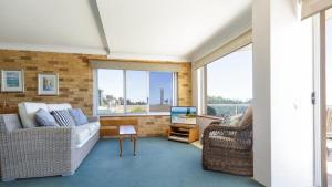 a living room with a couch and a tv at Lonerock Unit 2 in Yamba