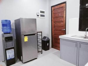 a kitchen with a stainless steel refrigerator and a sink at Minimalist 2 bedroom house in Opol +1 photo