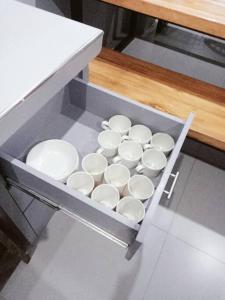 a tray of white cups in a drawer in a kitchen at Minimalist 2 bedroom house 