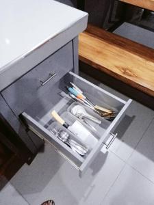 a drawer in a counter with utensils in it at Minimalist 2 bedroom house 