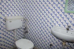 Laxmi Lodge في ريشيكيش: حمام مع مرحاض ومغسلة