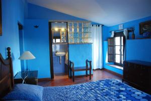 a blue bedroom with a bed and a sink at Posada La Casa Grande in Jimena de la Frontera