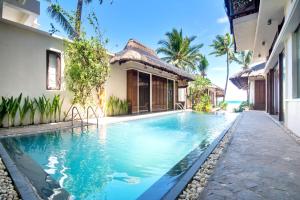 a swimming pool in front of a house at Harlan Beach Villa Boracay in Boracay