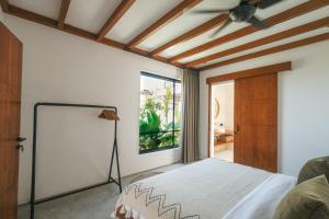 a bedroom with a bed and a ceiling fan at Botanique Villa & Studio in Tanah Lot