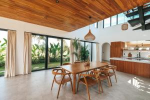 海神廟的住宿－Botanique Villa & Studio，开放式厨房以及带木桌和椅子的用餐室。
