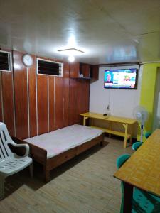 a room with a bed and a tv in it at Zeb's Transient House and Tour in Baguio