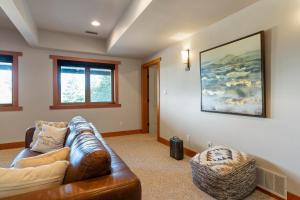 a living room with a leather couch and a painting at Shawnigan Hills Guest Suite in Shawnigan Lake