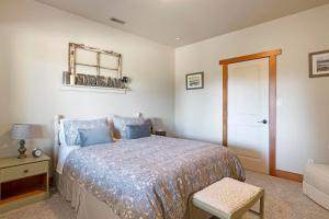 1 dormitorio con cama, silla y espejo en Shawnigan Hills Guest Suite en Shawnigan Lake