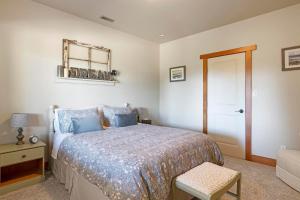 1 dormitorio con cama, silla y espejo en Shawnigan Hills Guest Suite, en Shawnigan Lake