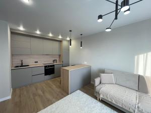 a living room with a couch and a kitchen at Freedom elite apartment in Astana