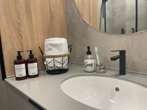 a bathroom sink with two bottles of soap and a mirror at Freedom elite apartment in Astana