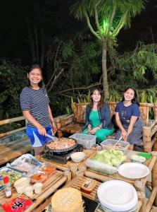 a group of three women standing around a table with food at Arapal Nature Retreat in Bogo
