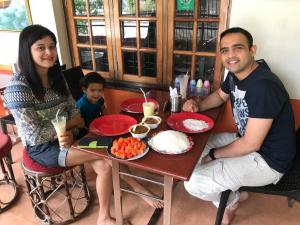 a man and a woman sitting at a table with food at Sajhome Fortkochi, Kochi, Kerala, inda in Cochin