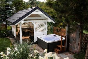 een tuinhuisje met een hot tub in de tuin bij Dom Oleńka- Kaszuby, weekend, wakacje, sauna, jacuzzi, jezioro in Garcz