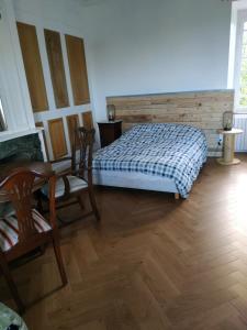 sypialnia z łóżkiem, stołem i krzesłami w obiekcie Maison de Maître - chambre chez particulier w mieście Landéan