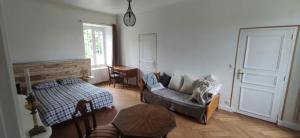 salon z kanapą i stołem w obiekcie Maison de Maître - chambre chez particulier w mieście Landéan