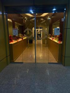 una puerta abierta a una tienda con flores. en فندق ادوماتو ADOMATo HOTEl, en Dawmat al Jandal