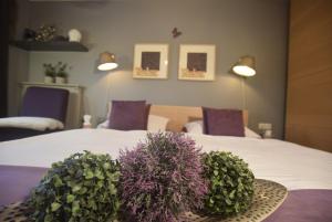 ein Schlafzimmer mit einem Bett mit lila Blumen darauf in der Unterkunft Gästehaus Waldeck in Grossgmain