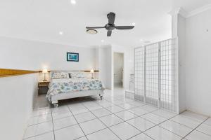 a bedroom with a bed and a ceiling fan at Smooth Sailing -Modern 2 bedroom apartment! in Bellara