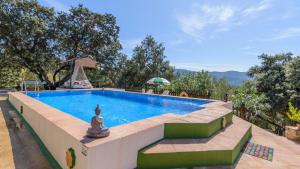 una gran piscina en un patio con árboles en El Castillejo Alpandeire by Ruralidays en Alpandeire