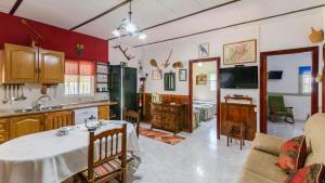 uma cozinha e sala de estar com uma mesa e uma televisão em El Castillejo Alpandeire by Ruralidays em Alpandeire