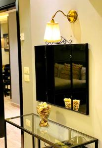 una mesa de cristal con lámpara y espejo en Elite Residency, en Amán