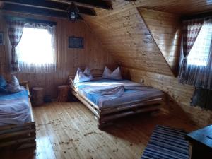 um quarto com uma cama num chalé de madeira em Casa de vacanta Vidrighin em Rau Sadului